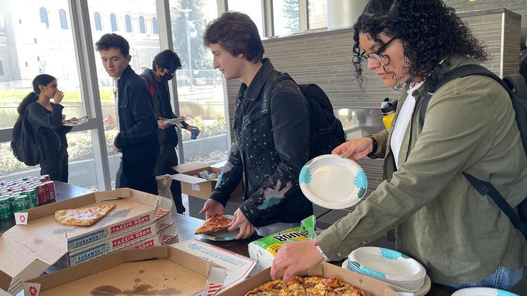 Students get a snack of pizza at buffet